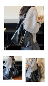 Detail view of large black leather tote bag with silver zipper and spacious interior