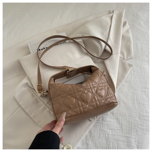 Close-up of heart-shaped quilted stitching and gold hardware on brown crossbody bag