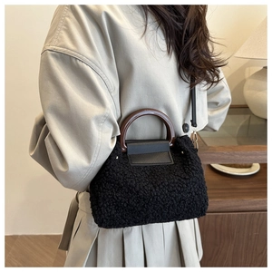 Détail de la texture en fausse fourrure noire avec poignées marron foncé et rabat en cuir