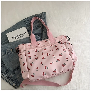 Détail du cabas rose imprimé cerises avec bandoulière amovible et poche zippée
