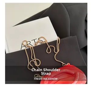 Detail of red lip-shaped acrylic clutch featuring a premium gold metal woven chain strap