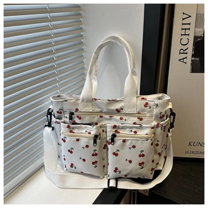 Détail du sac cabas à imprimé cerises avec poches zippées et bandoulière amovible réglable