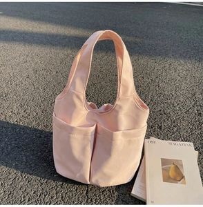Photo extérieure d'un sac cabas en nylon rose clair avec deux poches et des poignées