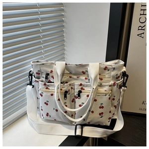 Détail du sac cabas blanc à imprimé cerise avec poches zippées et bandoulière réglable