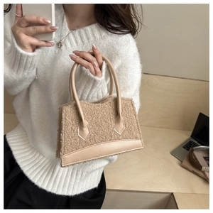 Detailed view of khaki fleece handbag with faux leather trim and sturdy top handle