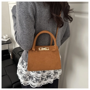 Dettaglio della borsa tote in pelle scamosciata caramello con fibbia dorata