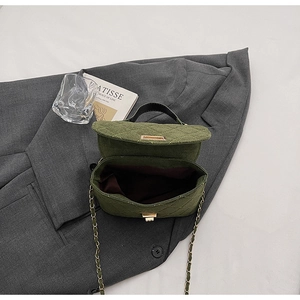 Detail view of the green quilted handbag with gold twist lock and spacious interior
