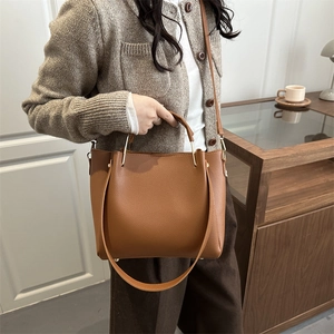 Brown litchi grain tote bag with metallic handles and long shoulder strap in cozy interior