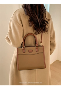 Prospettiva della borsa in pelle marrone su modella con un cappotto color cammello