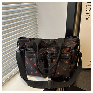 Détail du sac cabas noir imprimé cerises avec poches zippées et bandoulière réglable