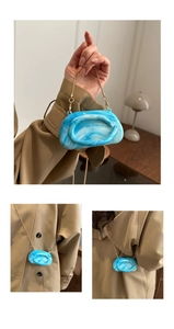 Detail of blue marble acrylic mini bag with gold chain strap on khaki trench coat