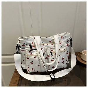 Vue détaillée du sac cabas imprimé cerises avec poches zippées et bandoulière large