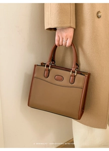 Dettaglio della borsa tote retrò bicolore marrone con texture in pelle e fibbia dorata