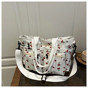 Vue détaillée du sac cabas à imprimé cerise avec plusieurs poches extérieures zippées