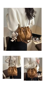 Brown suede bucket bag with drawstring closure, cartoon print and plush charm detail
