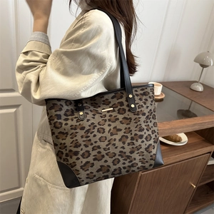 Large leopard print tote bag with black leather handles and gold rivet accents