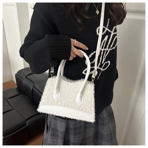 Detail of white faux shearling tote bag with PU leather base and detachable strap
