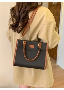 Dettaglio della borsa tote retrò nera e marrone indossata con un trench coat kaki