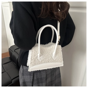 Détail du sac bandoulière en fausse fourrure blanche avec poignées en cuir chic