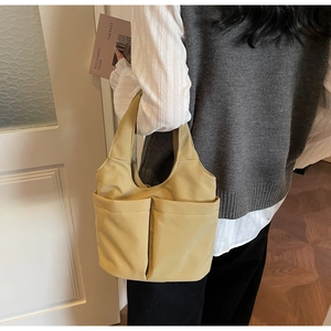 Détail d'un sac seau en nylon minimaliste avec deux poches avant et bandoulières