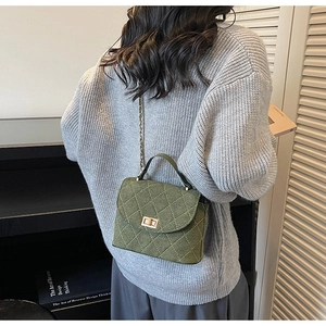 Detail of army green quilted tweed shoulder bag with chain strap and gold buckle