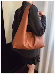Close-up of caramel brown leather tote bag showing soft texture and glossy finish