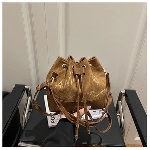 Detailed view of brown suede bucket bag with trendy graffiti print and drawstring closure