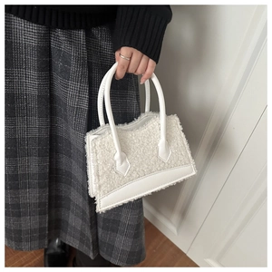 Détail d'un sac à main blanc en polaire sherpa et cuir pour la mode d'hiver