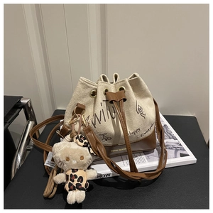 Detail of canvas bucket bag with cherry print and plush kitty pendant on fashion books