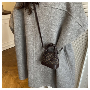 Mini vintage brown monogram shell bag with round handle worn over a grey wool coat