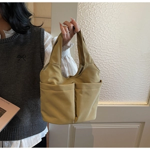 Vue détaillée du sac cabas en nylon jaune moutarde avec deux poches avant symétriques