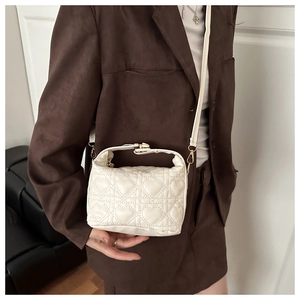 Detailed heart-shaped quilted pattern and golden metal hardware on a white crossbody bag