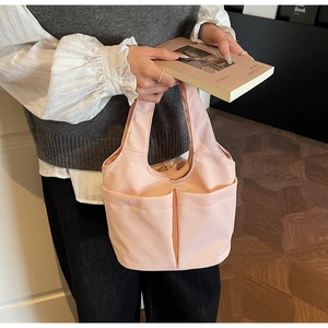 Détail du sac à main rose clair multi-poches avec texture nylon et larges anses