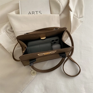 Sac à main vintage en daim marron montrant sa grande capacité pour téléphone et objets