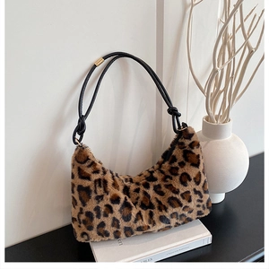 Détail du sac fourre-tout en fausse fourrure léopard avec lanières en cuir et anneaux