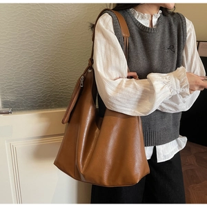 Brown leather tote bag featuring a spacious interior and soft matte texture detail