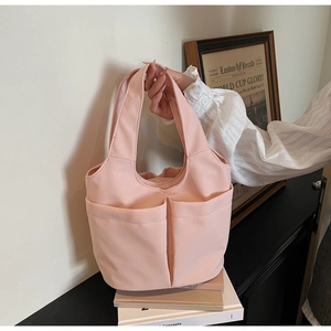 Sac seau en nylon rose montrant un matériau léger et deux grandes poches à l'avant