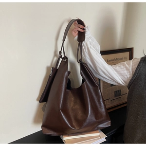 Detail of dark brown faux leather tote bag with matching coin purse and oil wax finish