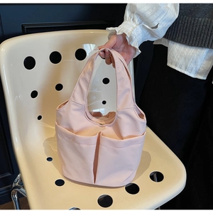 Vue détaillée du sac fourre-tout en nylon rose avec deux poches frontales