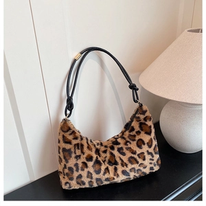 Detail of leopard print faux fur shoulder bag with knotted black strap and gold metal hardware
