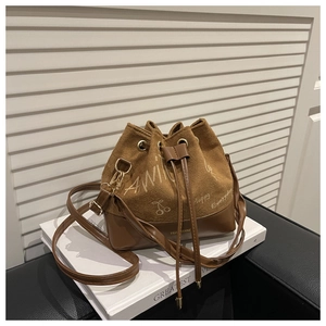 Detail of vintage brown bucket bag with graffiti prints and smooth leather stitching