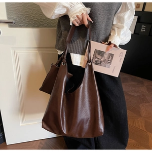 Close-up of large dark brown leather hobo tote bag with matching small organizer pouch