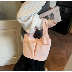 Détail du sac fourre-tout en nylon rose clair avec deux poches avant et anses