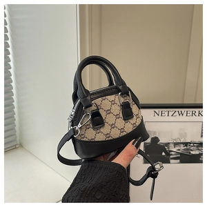Close-up of shell handbag featuring retro checkered pattern and black leather handles