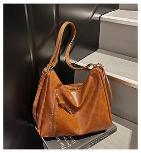 Detailed macro of brown vintage leather tote with vertical zip and embossed logo