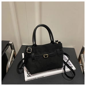 Détail du sac à main noir mat avec boucle dorée et fine bandoulière amovible