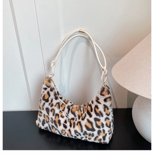 Detail of plush leopard print hobo bag with white woven rope handle and golden metal rings