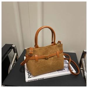 Détail d'un sac cabas vintage en daim marron avec lanière en cuir et boucle dorée