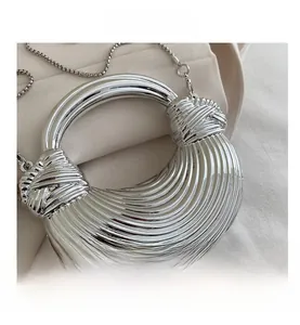 Dettaglio della borsa ad anello argento con texture a onde e nodo decorativo