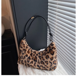 Macro view of plush leopard print crescent bag texture with black leather strap